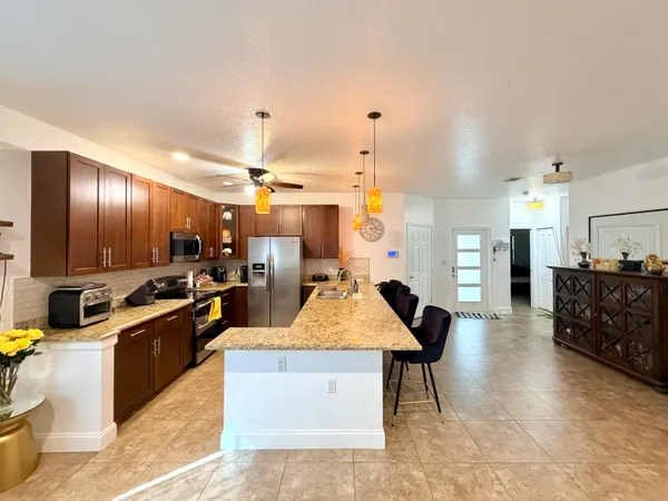a kitchen with stainless steel appliances kitchen island granite countertop a sink counter space and cabinets