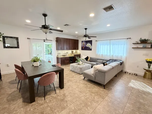 a living room with furniture kitchen view and a flat screen tv