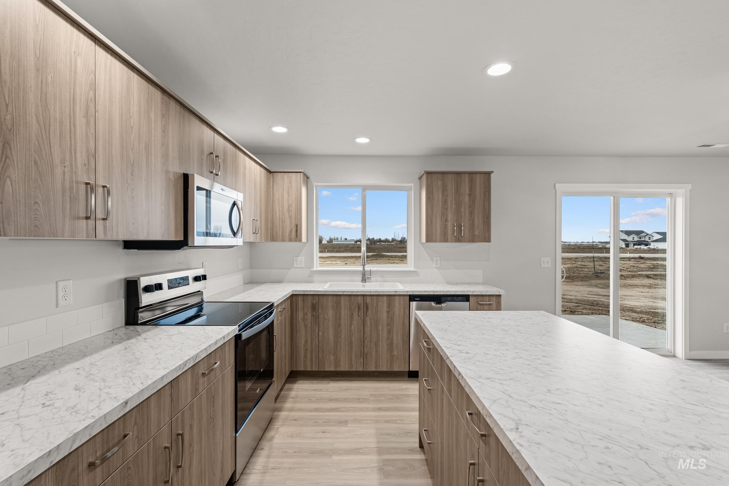 13693 Redway Court Caldwell, ID 83607 - Photo 4 of 25 Kitchen featuring stainless steel appliances, light wood finished floors, modern cabinets, light countertops, and recessed lighting