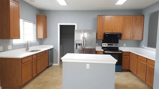 a kitchen with a sink stove and refrigerator