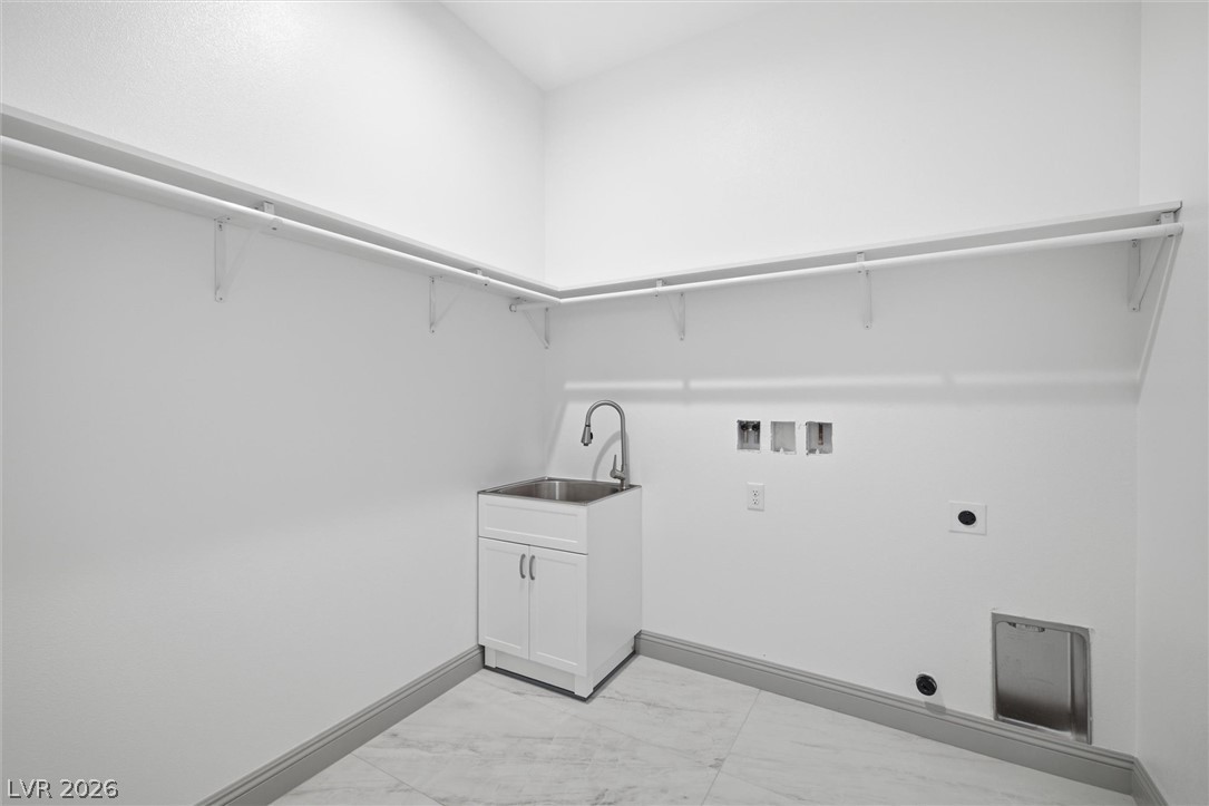 1061 Factory Road Pahrump, NV 89048 - Photo 29 of 41 Functional laundry room featuring a convenient sink and ample overhead shelving for storage.