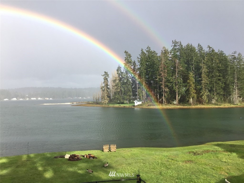 an aerial view of a residential houses with outdoor space and trees all around
