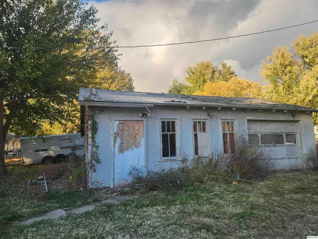 a view of a house with a small yard and large tree