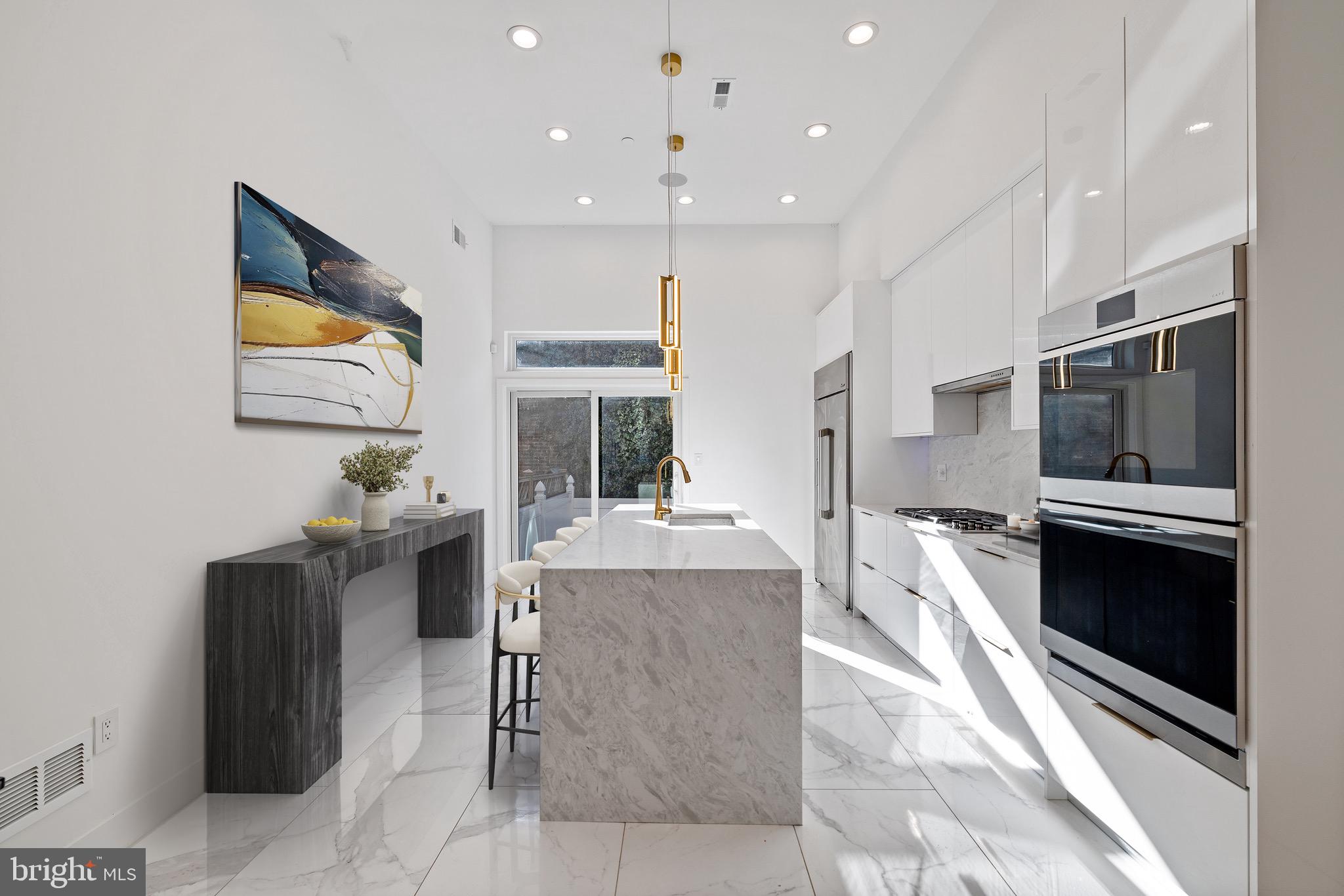 2130 Spring Street Philadelphia, PA 19103 - Photo 12 of 59 a kitchen with stainless steel appliances kitchen island granite countertop a sink and cabinets