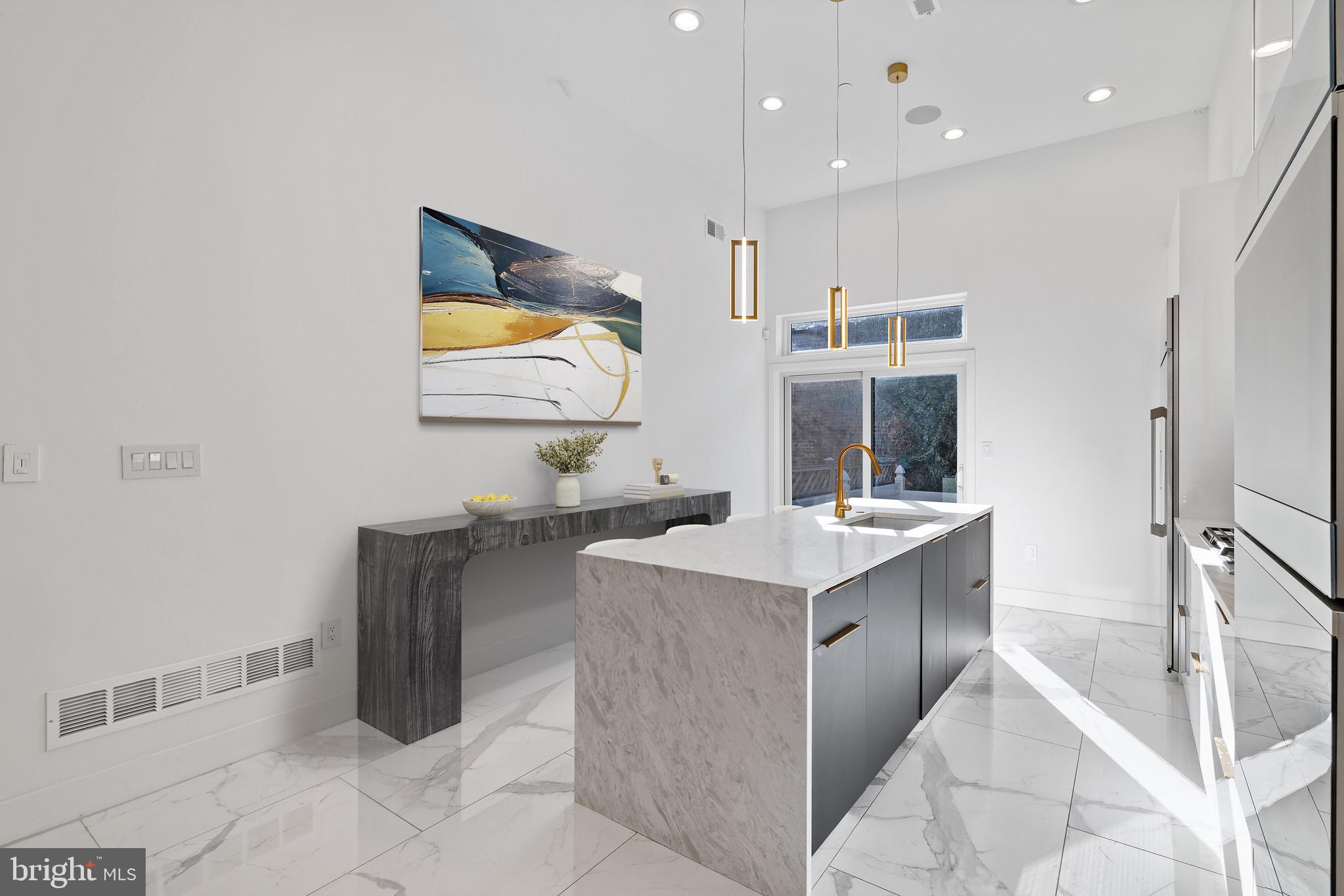 2130 Spring Street Philadelphia, PA 19103 - Photo 13 of 59 a kitchen with a sink refrigerator and chairs