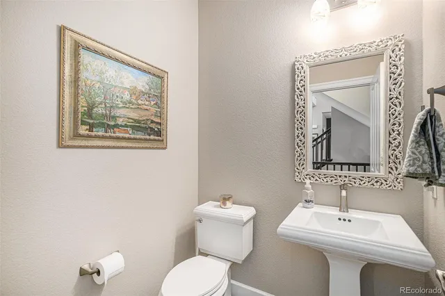 a bathroom with a toilet a sink and mirror