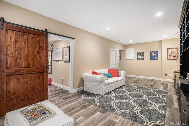 a living room with a couch and a dresser with wooden floor