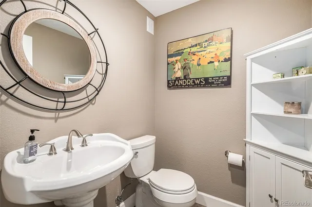 a bathroom with a toilet a sink and a mirror