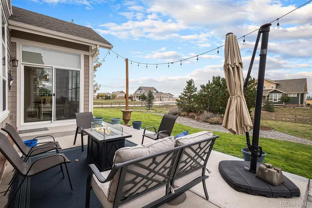 a view of a patio with a table chairs and a wooden deck