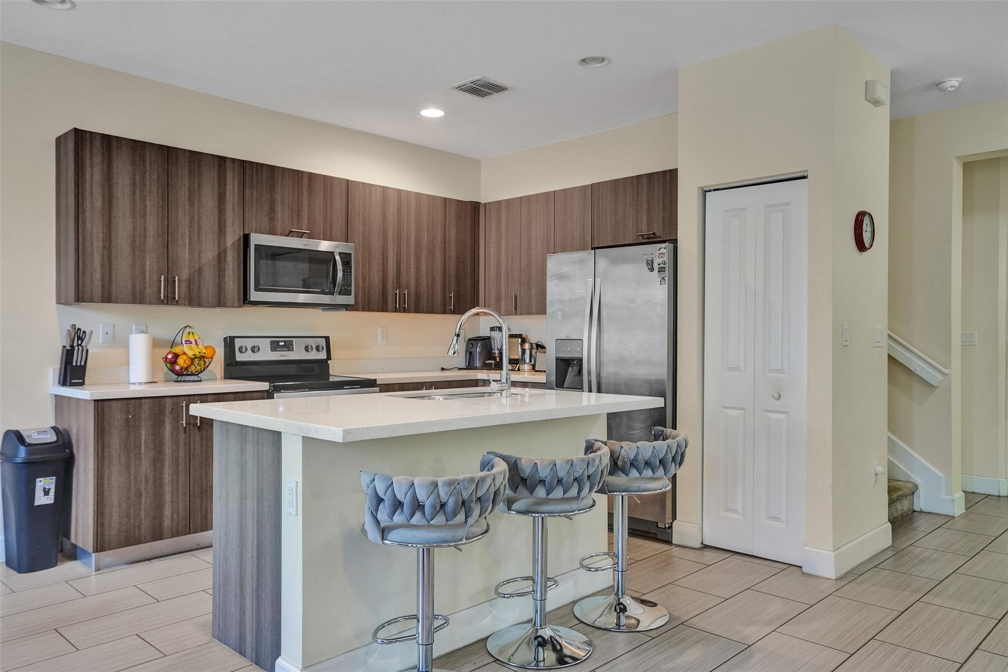 4875 Northwest 55th Place Tamarac, FL 33319 - Photo 18 of 44 a kitchen with a refrigerator a stove a sink and chairs