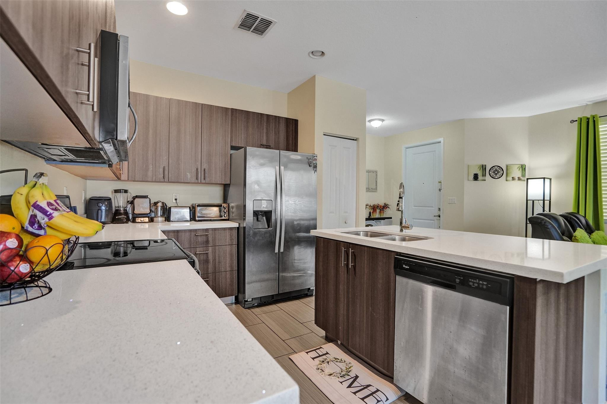 4875 Northwest 55th Place Tamarac, FL 33319 - Photo 21 of 44 a kitchen with stainless steel appliances a sink a stove a refrigerator cabinets and a counter top space