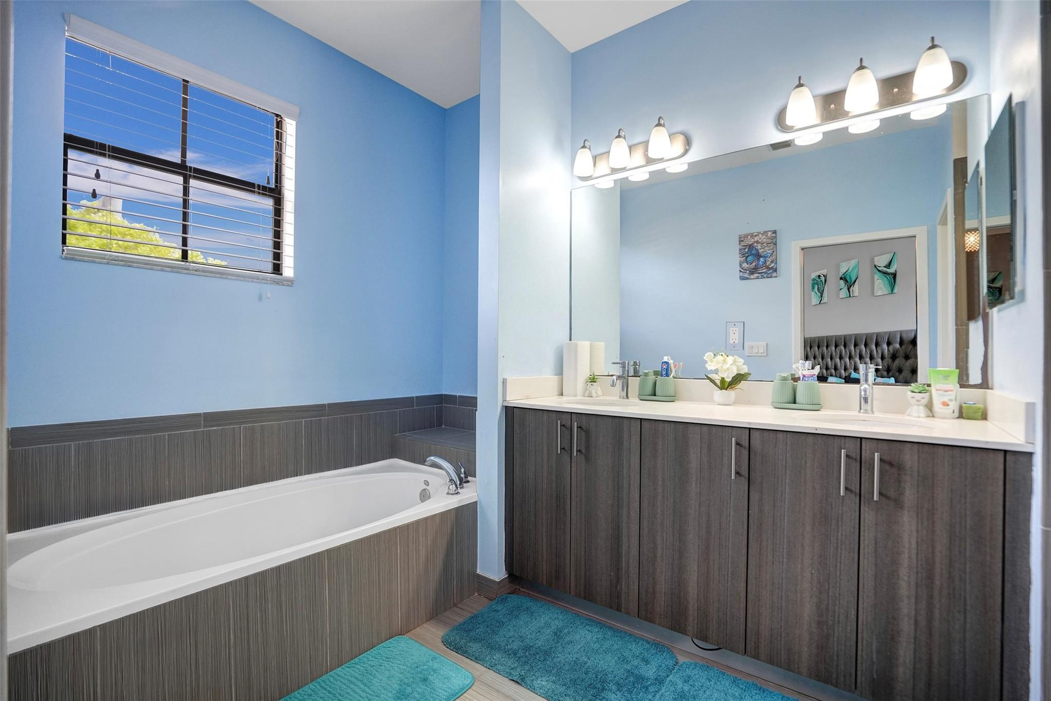 4875 Northwest 55th Place Tamarac, FL 33319 - Photo 27 of 44 a bathroom with a bathtub a sink and a large mirror