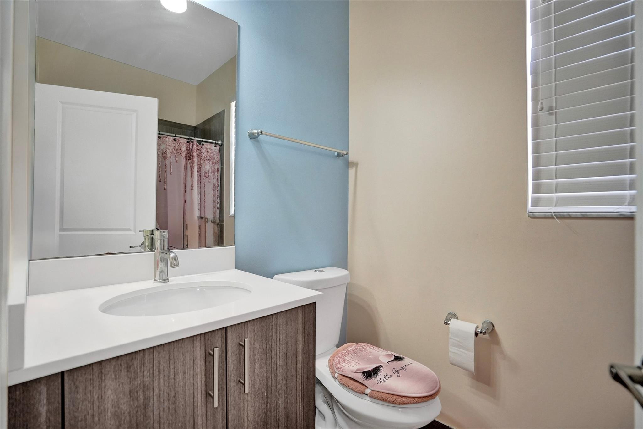 4875 Northwest 55th Place Tamarac, FL 33319 - Photo 33 of 44 a bathroom with a sink a toilet and a mirror