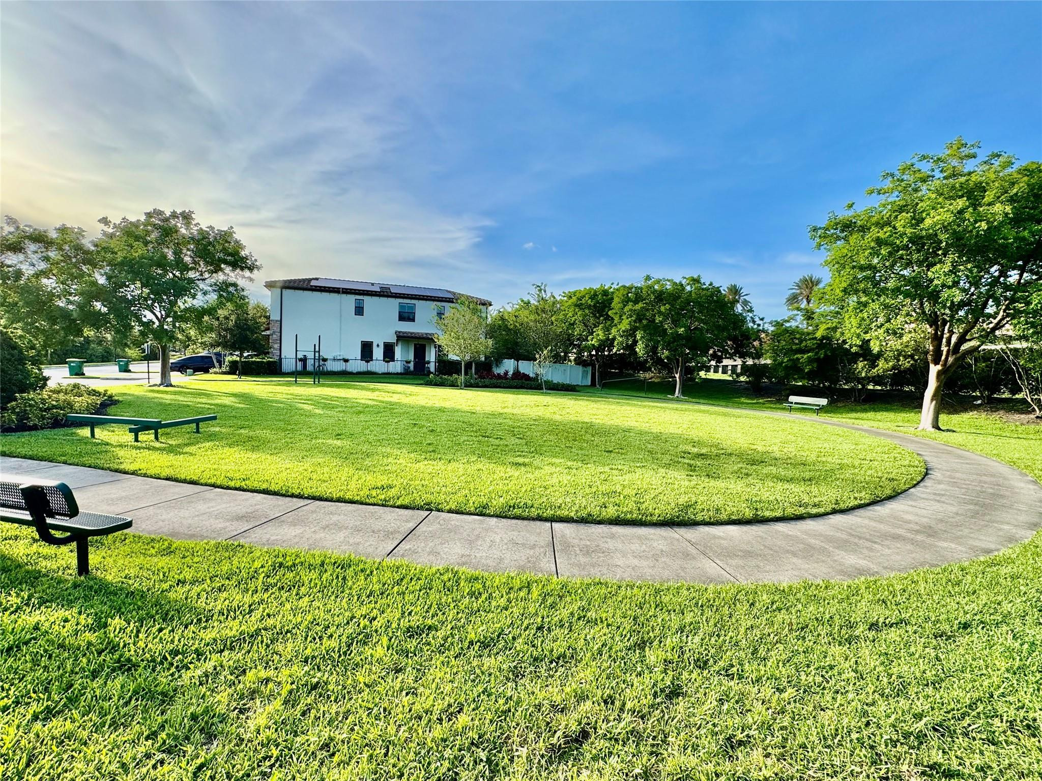 4875 Northwest 55th Place Tamarac, FL 33319 - Photo 38 of 44 a view of a big yard with a bench and trees