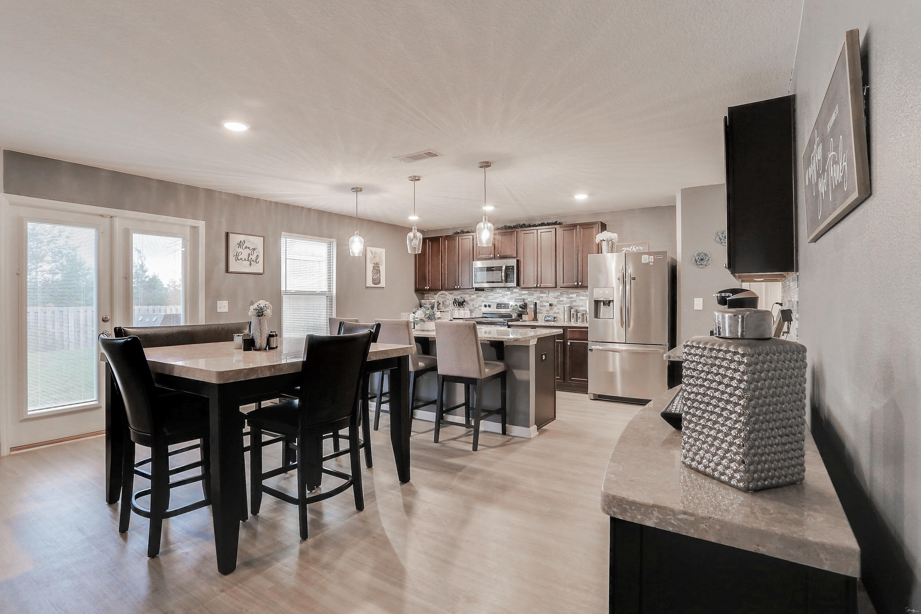 358 Merlin Court Crestview, FL 32539 - Photo 13 of 45 a kitchen with a dining table chairs and flat screen tv