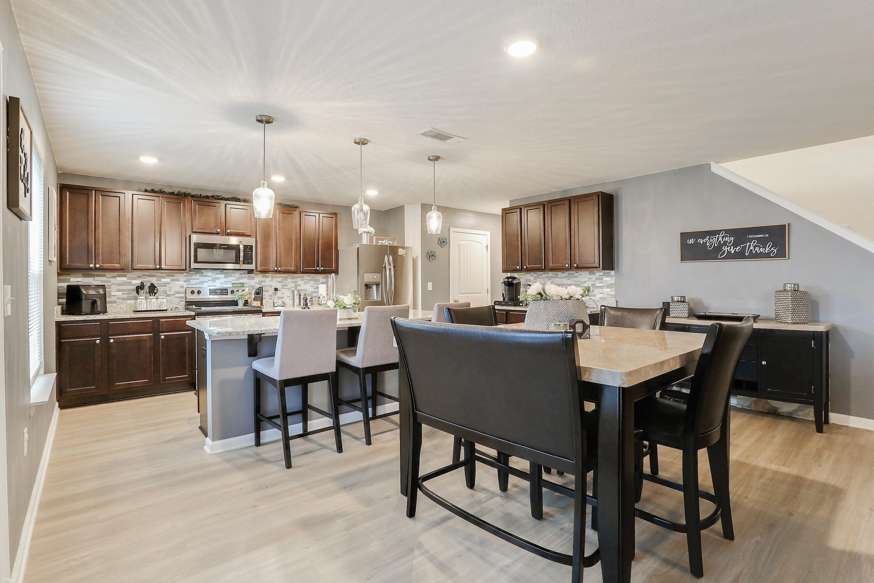 358 Merlin Court Crestview, FL 32539 - Photo 14 of 45 a kitchen with stainless steel appliances kitchen island granite countertop a sink a stove a dining table and chairs