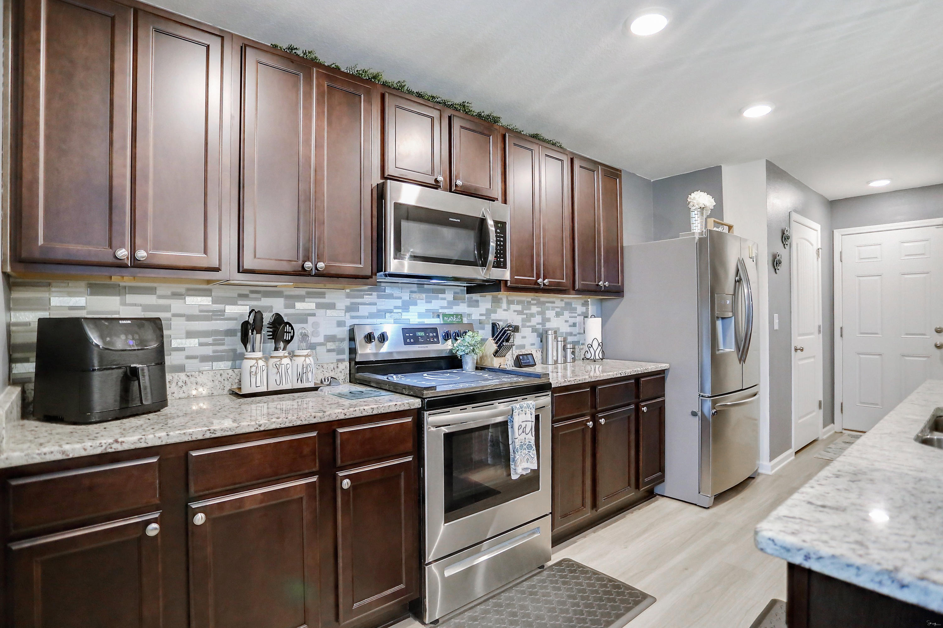 358 Merlin Court Crestview, FL 32539 - Photo 20 of 45 a kitchen with stainless steel appliances granite countertop wooden cabinets a stove top oven a sink and dishwasher