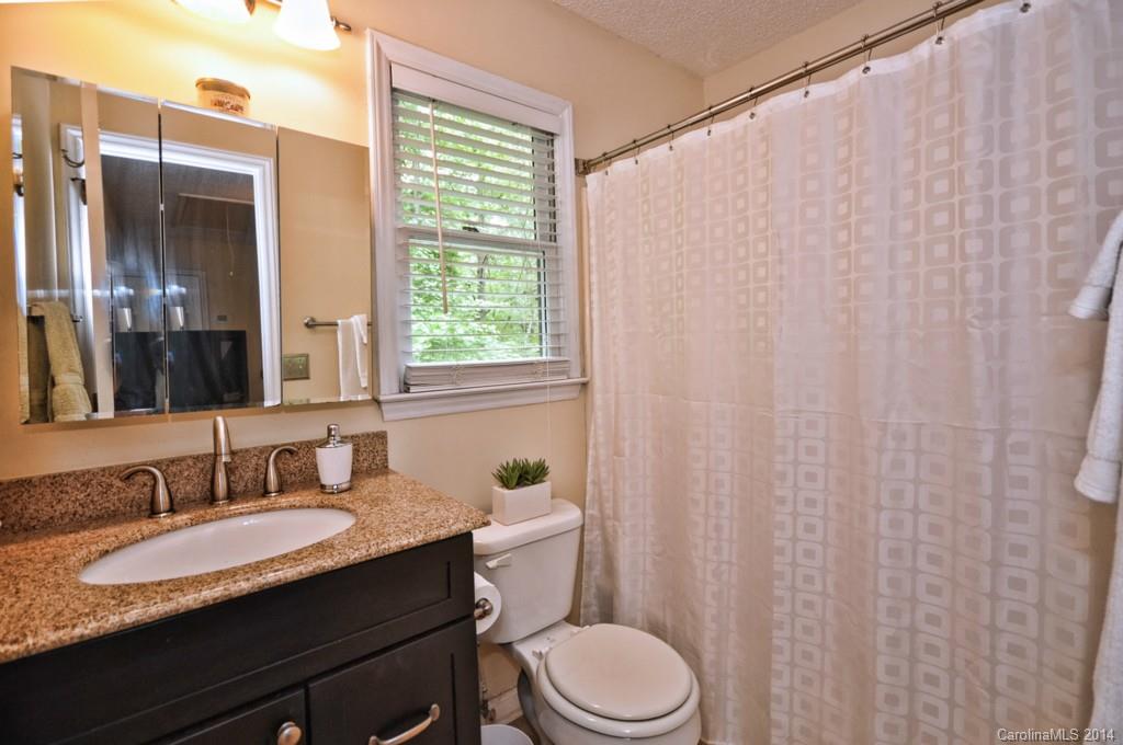 31017 Executive Point Tega Cay, SC 29708 - Photo 13 of 22 a bathroom with a granite countertop sink toilet and mirror