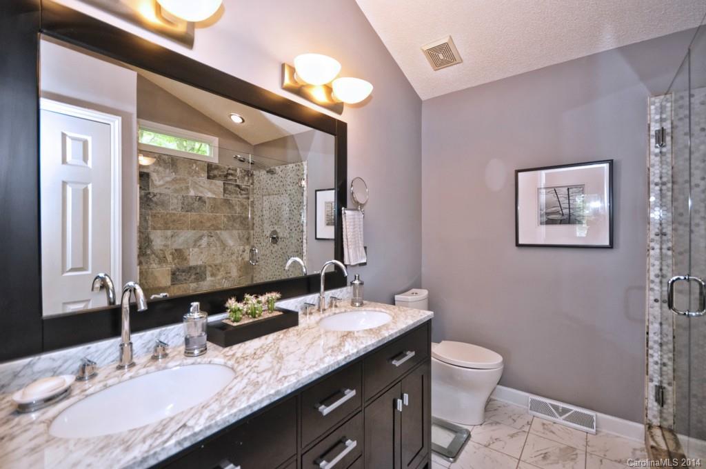 31017 Executive Point Tega Cay, SC 29708 - Photo 7 of 22 a bathroom with a granite countertop sink a toilet and a mirror