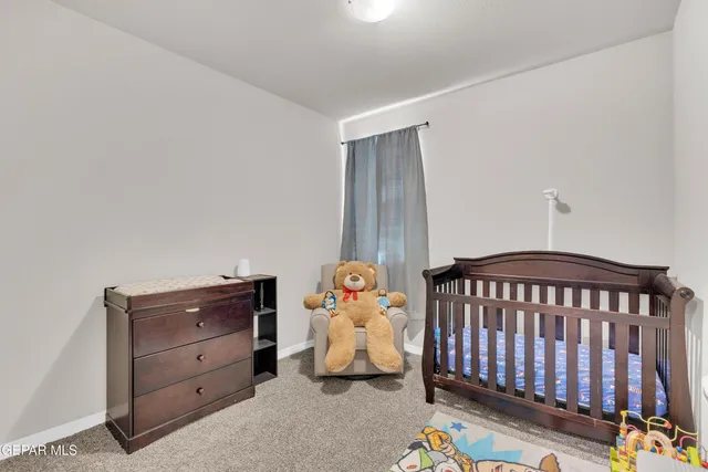 a bedroom with a baby bed baby crib and a dresser