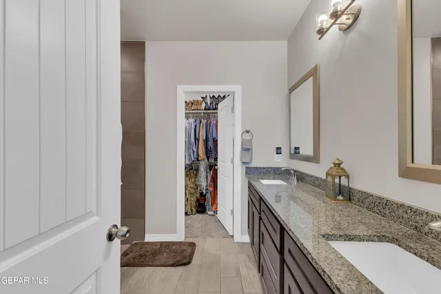 a bathroom with a granite countertop sink and a mirror