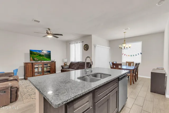 a kitchen with a counter space a sink and living room view
