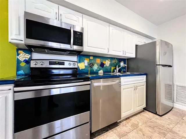 a kitchen with stainless steel appliances a stove a microwave and a refrigerator