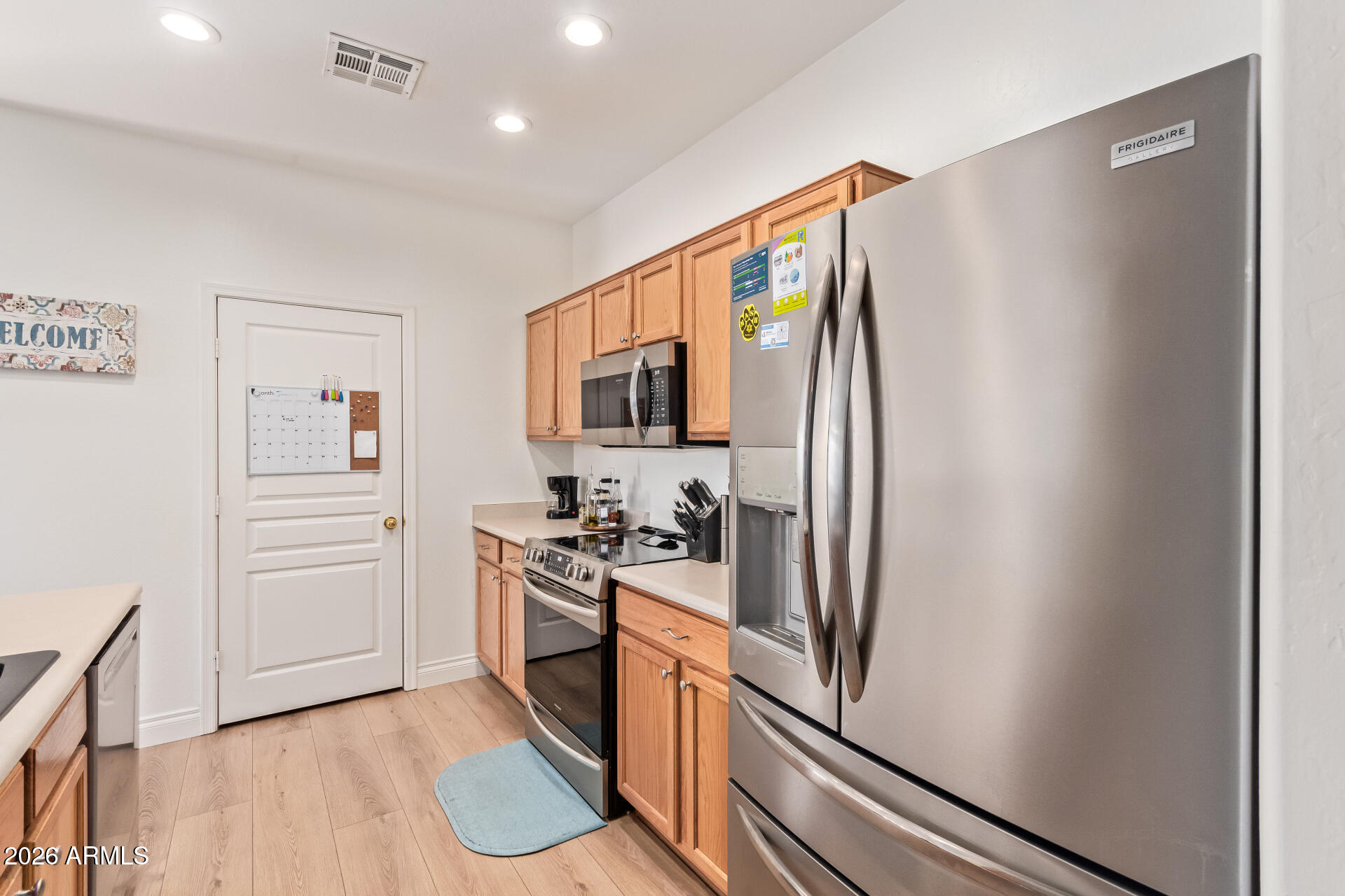 16805 West Rimrock Street Surprise, AZ 85388 - Photo 13 of 42 a kitchen with stainless steel appliances granite countertop a refrigerator and a stove top oven