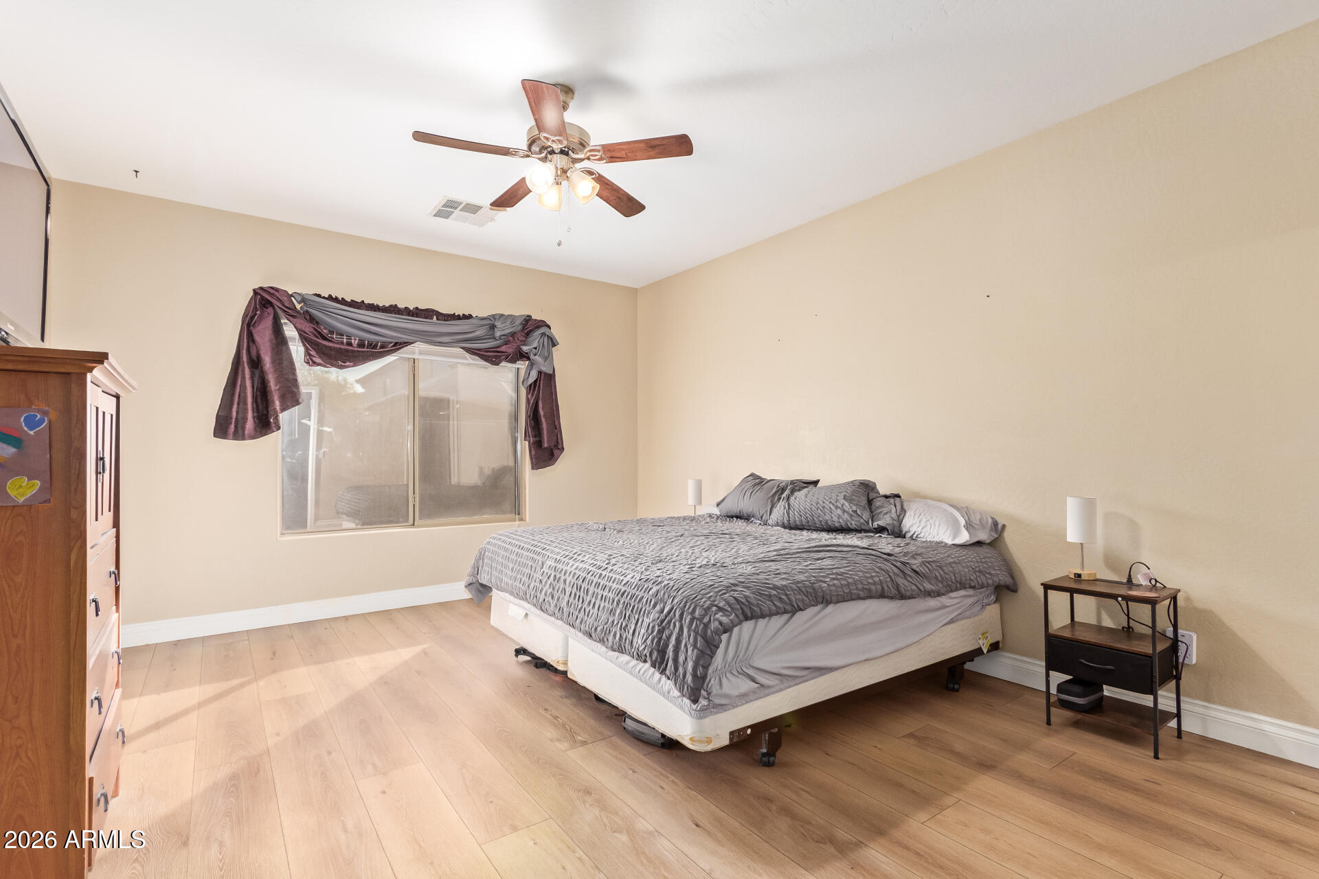 16805 West Rimrock Street Surprise, AZ 85388 - Photo 17 of 42 a spacious bedroom with a bed and a chandelier