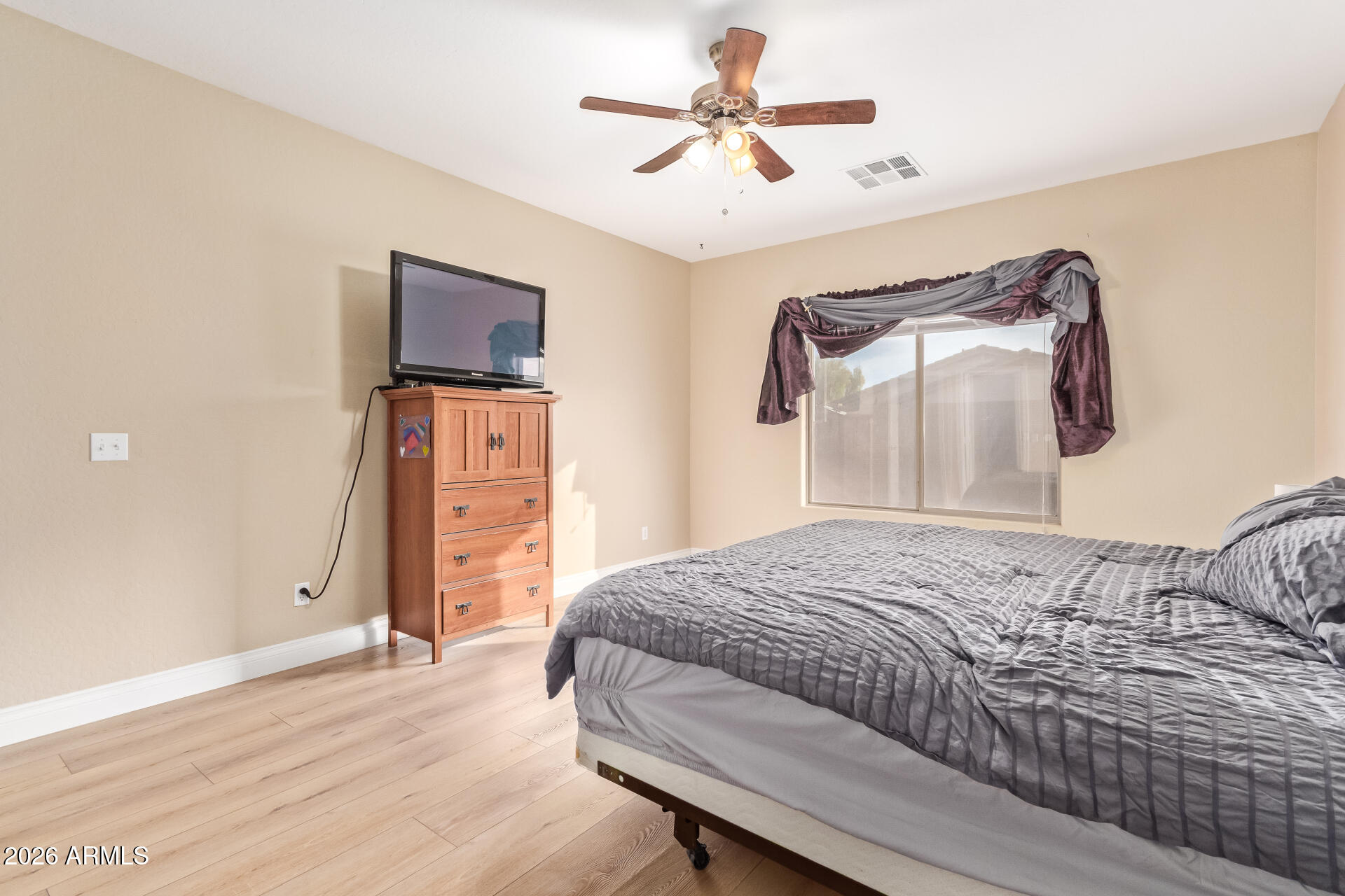16805 West Rimrock Street Surprise, AZ 85388 - Photo 19 of 42 a bedroom with a bed and a chandelier