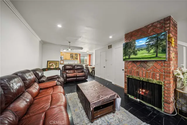 a living room with furniture a flat screen tv and a fireplace