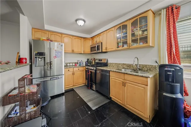 a kitchen with stainless steel appliances granite countertop a refrigerator a stove and a sink