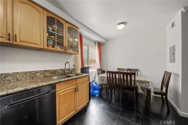 a kitchen with stainless steel appliances granite countertop a stove a sink dishwasher and cabinets with wooden floor