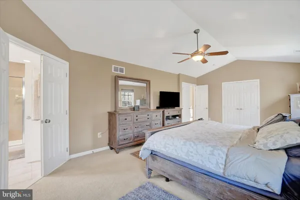 a bedroom with a bed a window and a flat screen tv