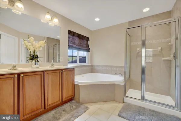 a bathroom with a bathtub shower sink mirror and toilet