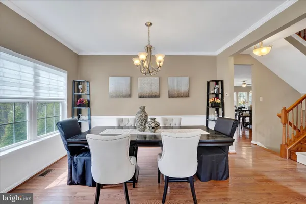 a view of a dining room with furniture wooden floor and chandelier