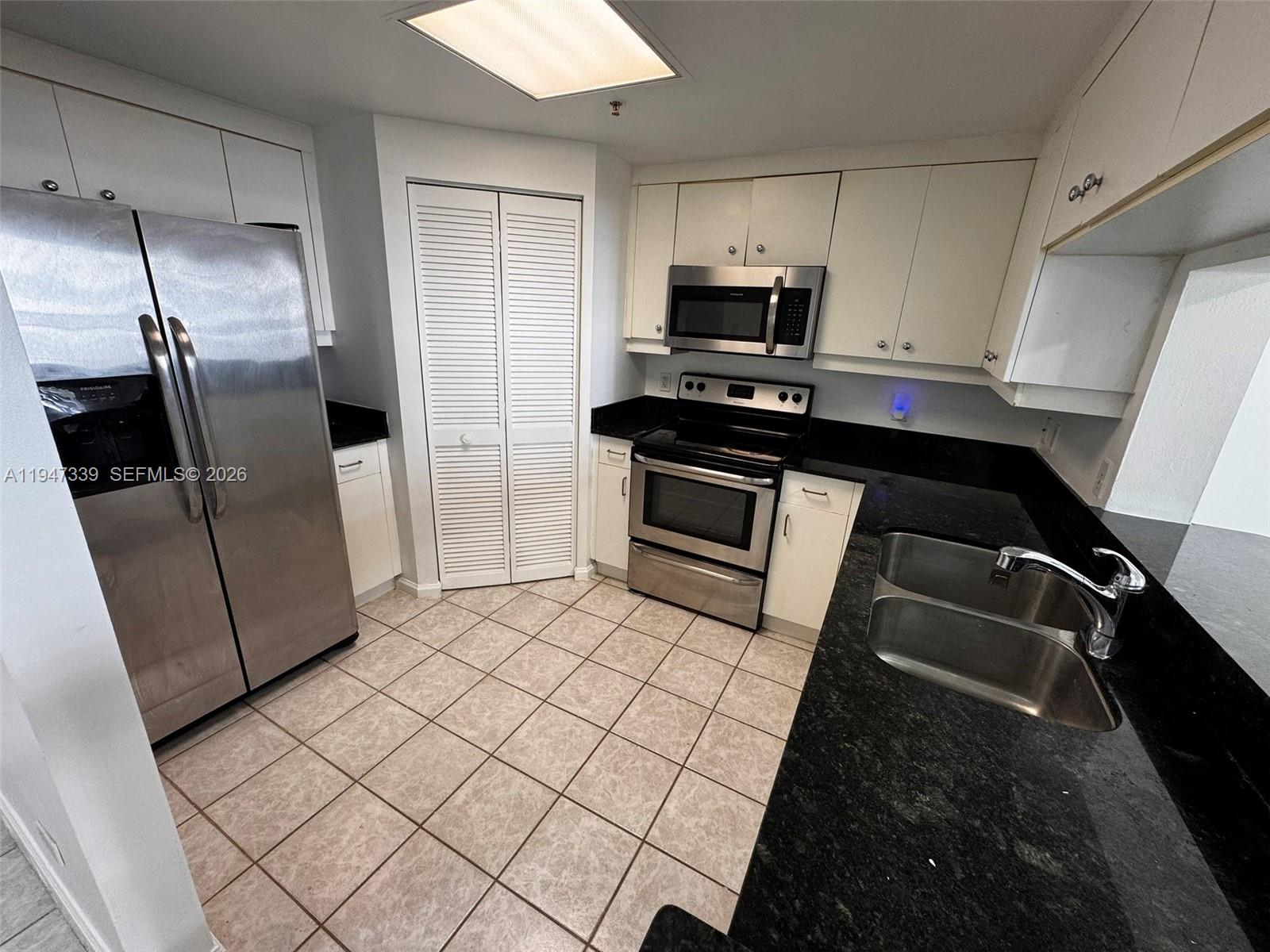 701 Brickell Key Boulevard, Unit 1208 Miami, FL 33131 - Photo 11 of 14 a kitchen with a refrigerator and a sink