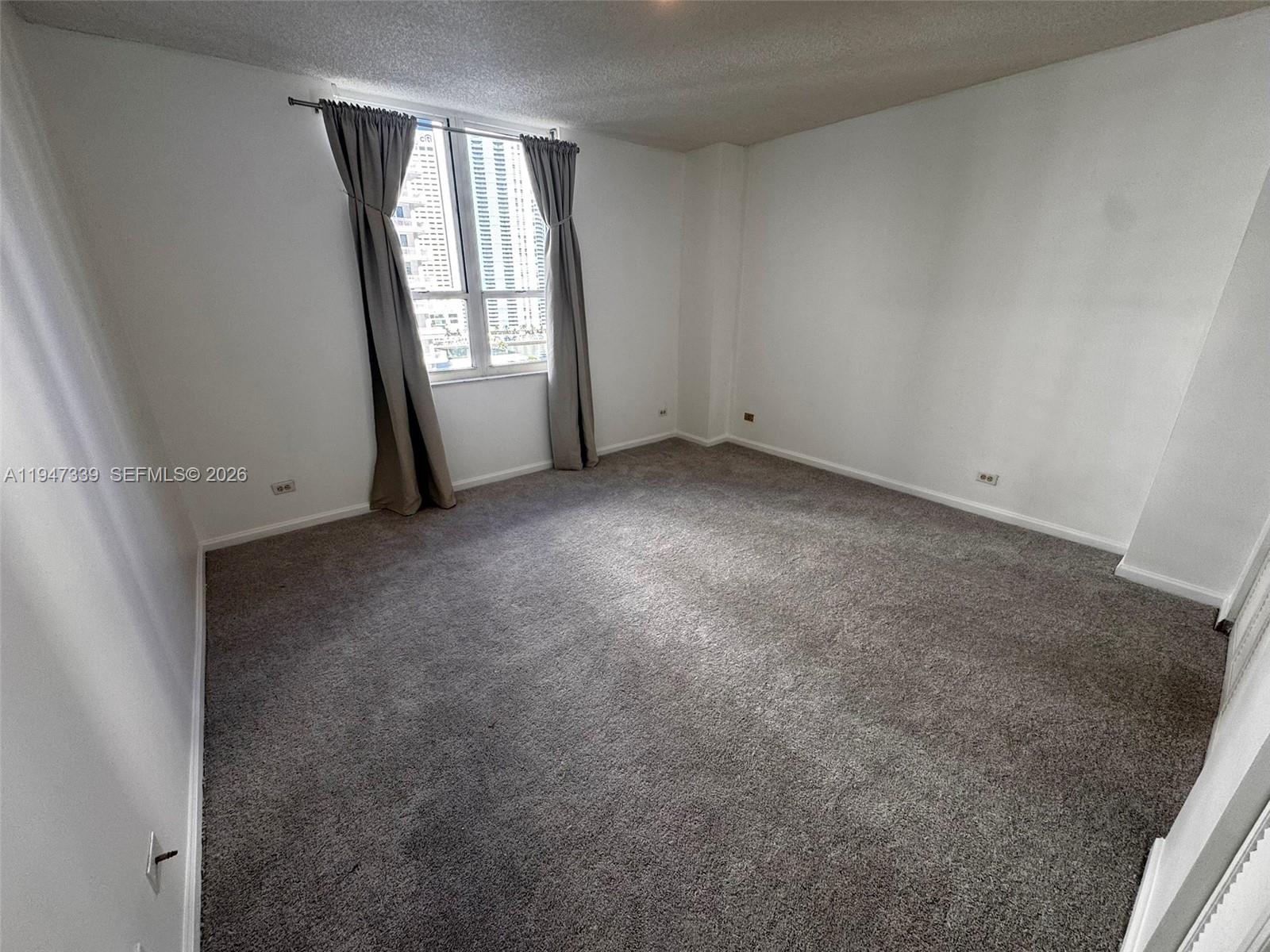 701 Brickell Key Boulevard, Unit 1208 Miami, FL 33131 - Photo 8 of 14 an empty room with windows