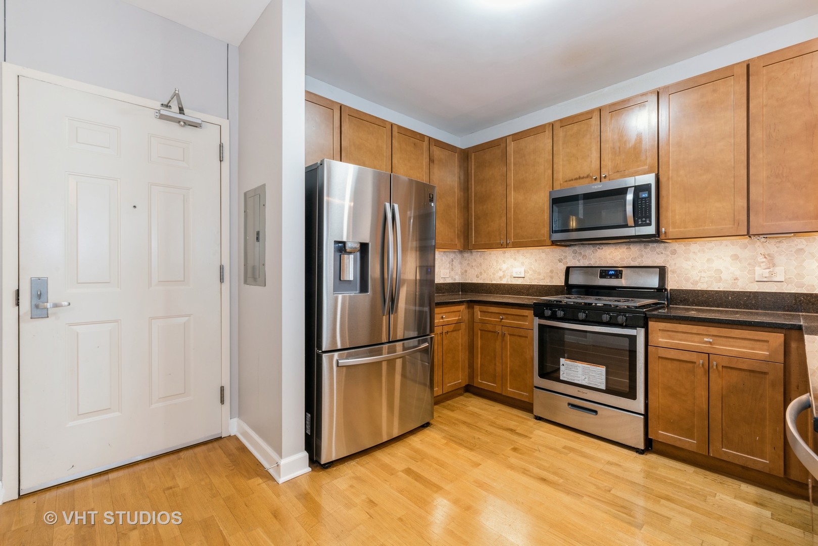 1600 South Prairie Avenue, Unit 2005 Chicago, IL 60616 - Photo 3 of 12 a kitchen with granite countertop a refrigerator and a stove top oven