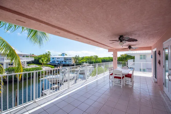 a view of a chairs and table in patio with swimming pool