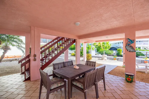 a view of a patio with a table chairs and a floor to ceiling window