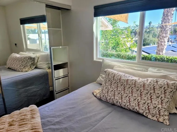 a bedroom with a bed and a large window