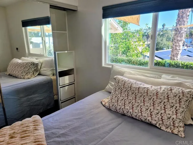 a bedroom with a bed and a large window