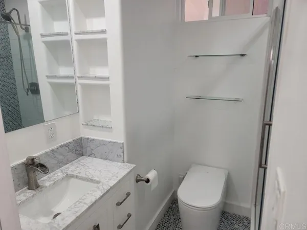 a bathroom with a granite countertop sink toilet and a mirror
