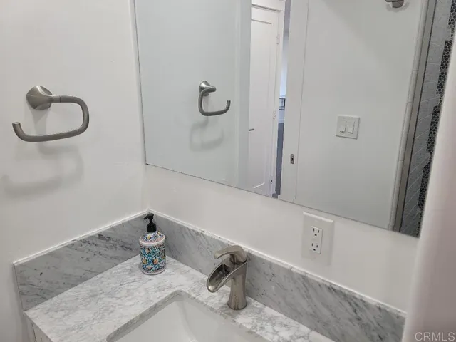 a bathroom with a granite countertop sink