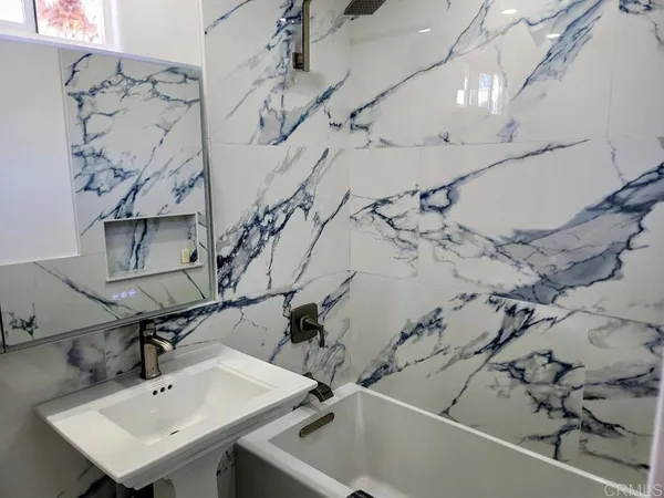 a bathroom with a sink a toilet and a mirror