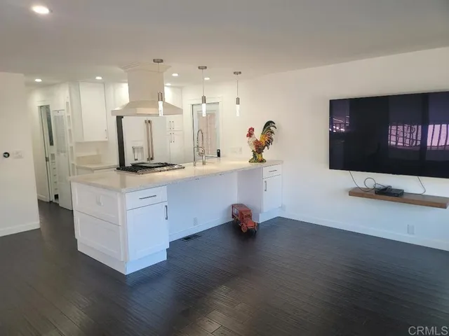 a kitchen with stainless steel appliances refrigerator stove and wooden floor