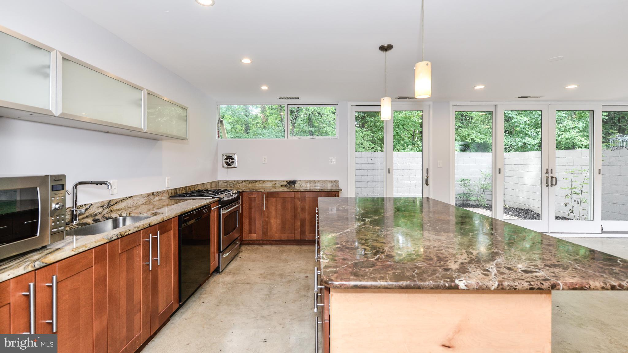 11533 Hickory Cluster Reston, VA 20190 - Photo 3 of 30 a kitchen with kitchen island granite countertop a sink a counter top space and stainless steel appliances
