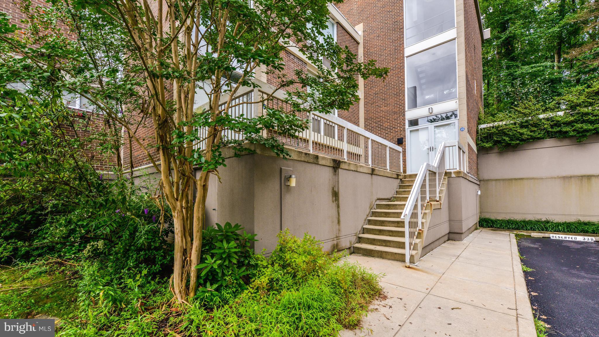 11533 Hickory Cluster Reston, VA 20190 - Photo 30 of 30 a view of a pathway of a house with large trees and plants