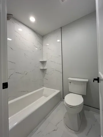 a bathroom with a toilet and a shower